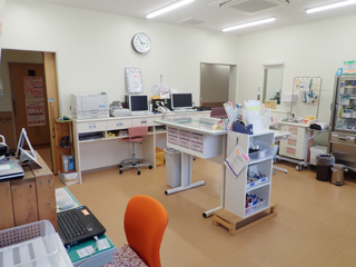 室内の中央に薬剤などが置かれているテーブルのワゴンがある処置室の写真