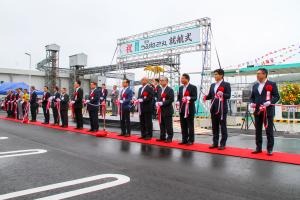 宮古うみねこ丸の就航式の中で、たくさんのスーツを着た人々が横一列にならんでテープカットをしている様子を斜め前から写した写真