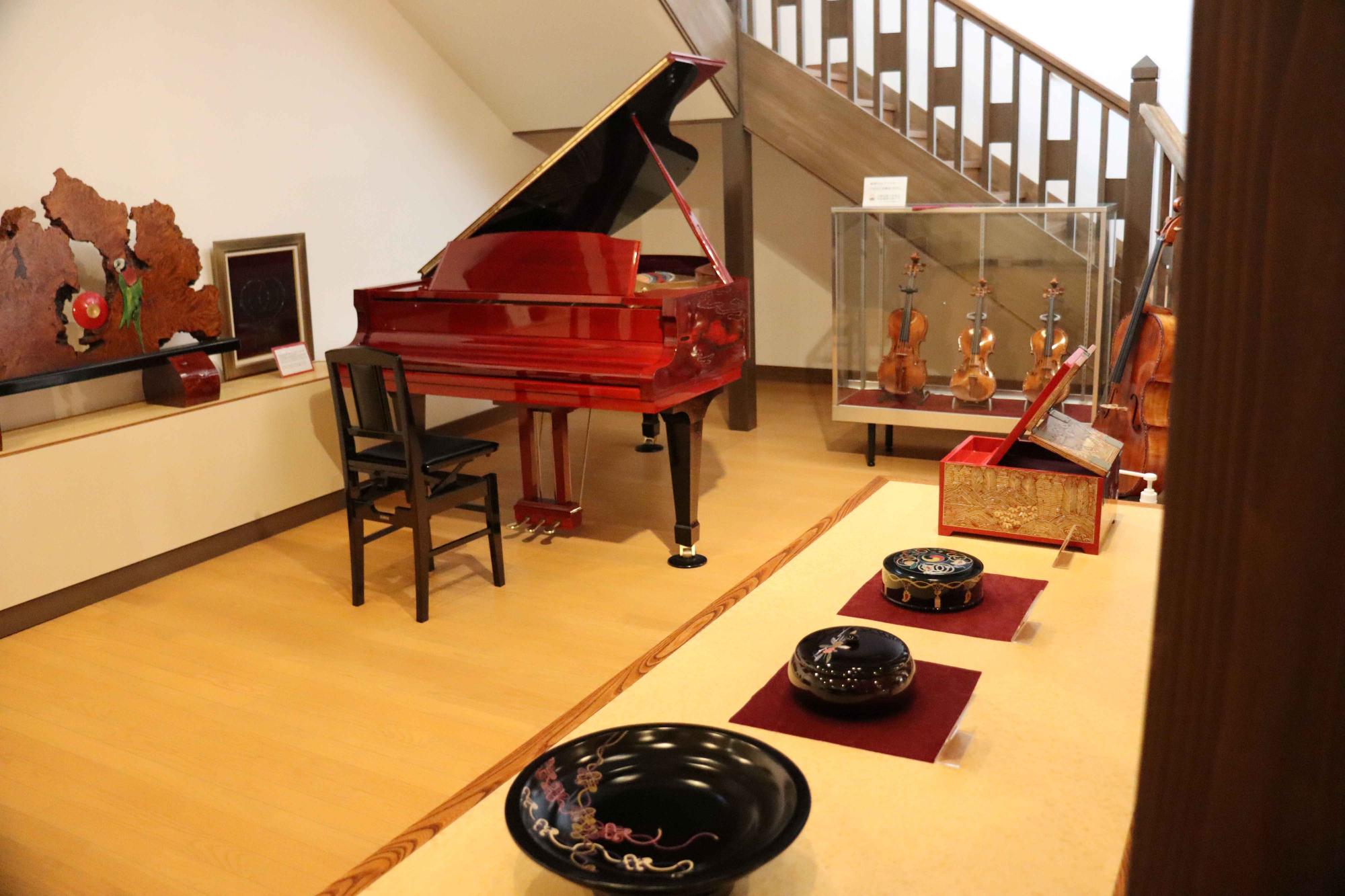 薬師塗漆工芸館1階の展示品の写真です。漆塗りのピアノが写っています。