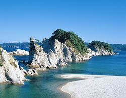 海から大きな岩がそびえ立っている風景写真
