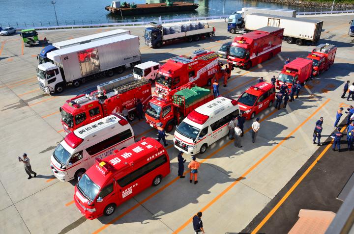 消防車や救急車など10台が3列に並び港に停車している様子を空撮した写真