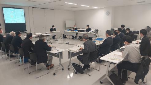 たくさん設置された長机に関係者の方々が座り会議が行われている室内を写した写真