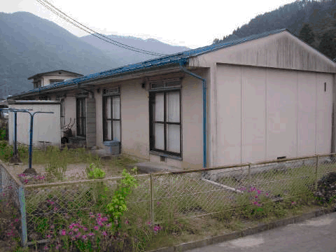 一戸建て住宅が隣り合わせで並んでいる平屋建て長屋住宅を庭側から撮影した写真