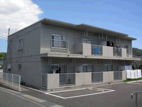 建物前に駐車場が設けられた2階建て集合住宅の写真