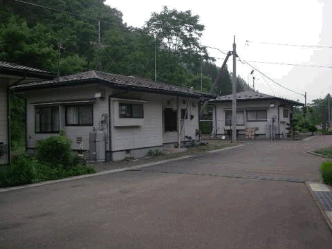 グレーの外壁の和美団地住宅が道路沿いに並んでいる写真