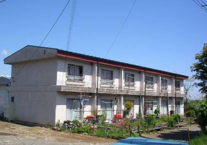 隣り合わせで並んでいる2階建て長屋の赤前住宅の写真