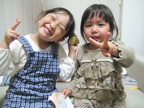 2人の女の子が笑顔でピースサインをしている写真