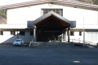 玄関の屋根が三角の屋根になっていて入口前に段差がある新里健康増進施設の外観写真