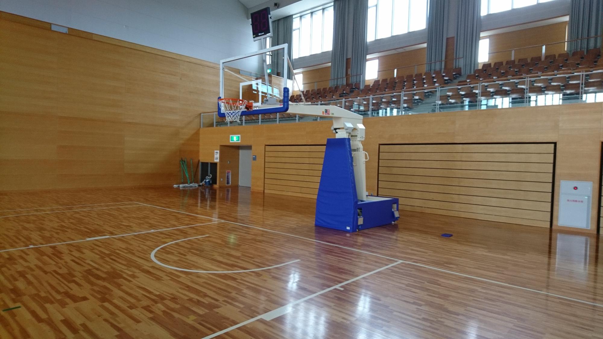 体育館の1面に設置された白と青の配色のバスケットゴールの写真