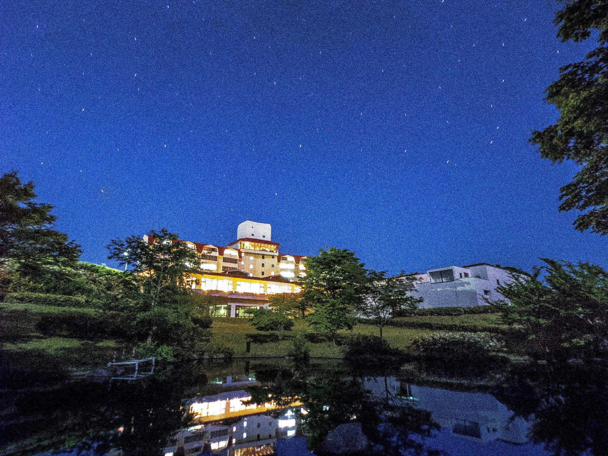 星空の下、建物の照明が付近の池に映り幻想的なグリーンピア三陸みやこの写真