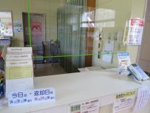 白いテーブルの受付台のところに透明のアクリル板が設置されている写真