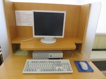 モニターが見えないように仕切りがされ段差があるテーブルにモニターとキーボードが置かれている写真