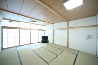 障子から明るい光がもれている畳の部屋で部屋の角にテレビが設置されている和室内の写真