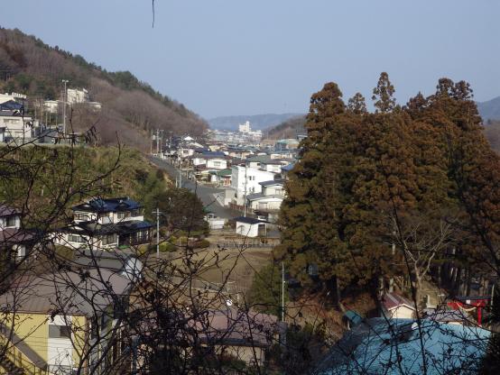 木々に合い間から遠くの山々や住宅街も見下ろすことができる八木沢新館跡 三の郭から見れる八木沢の風景の写真