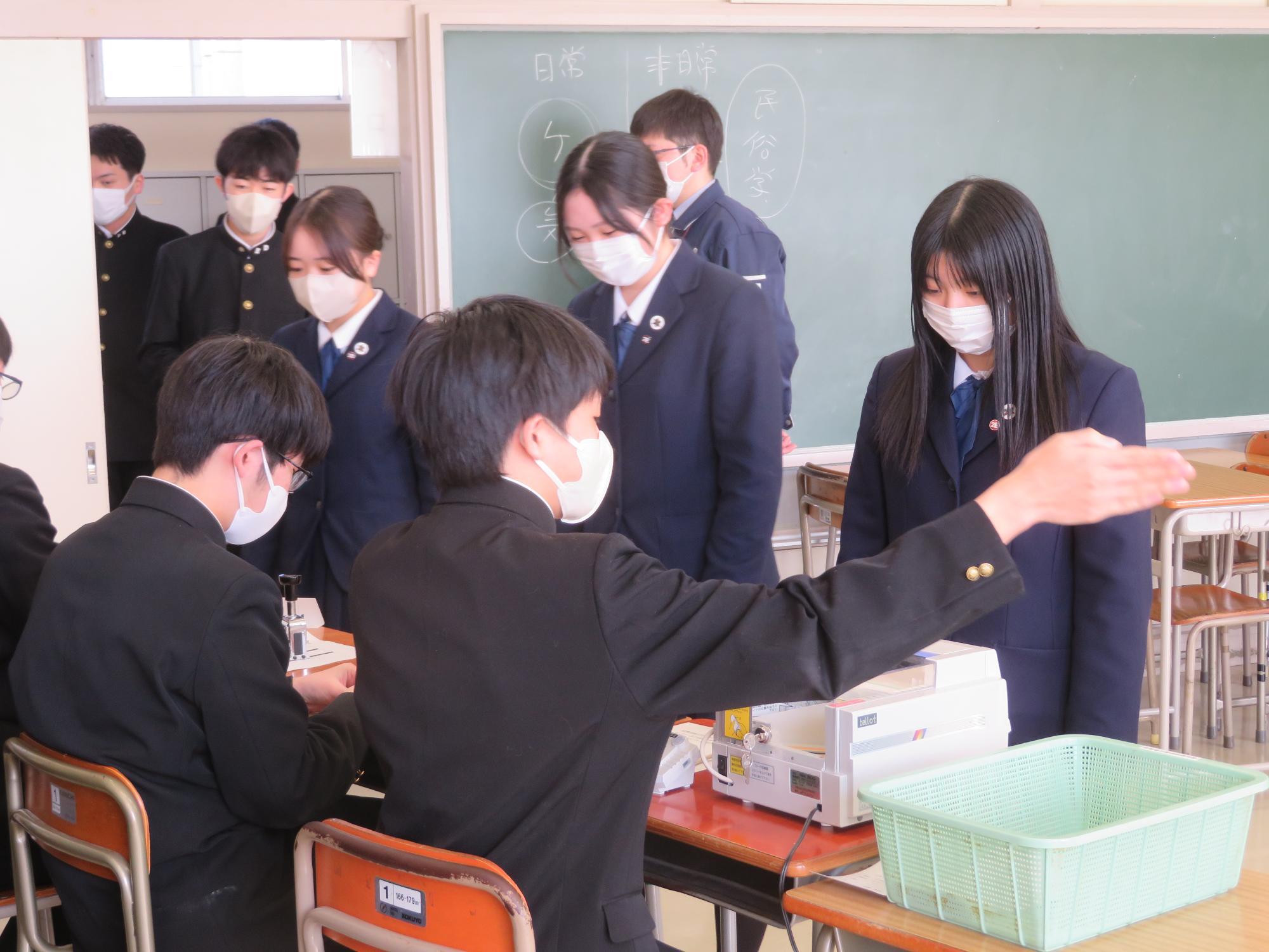 選挙人を記載台に案内する高校生スタッフ