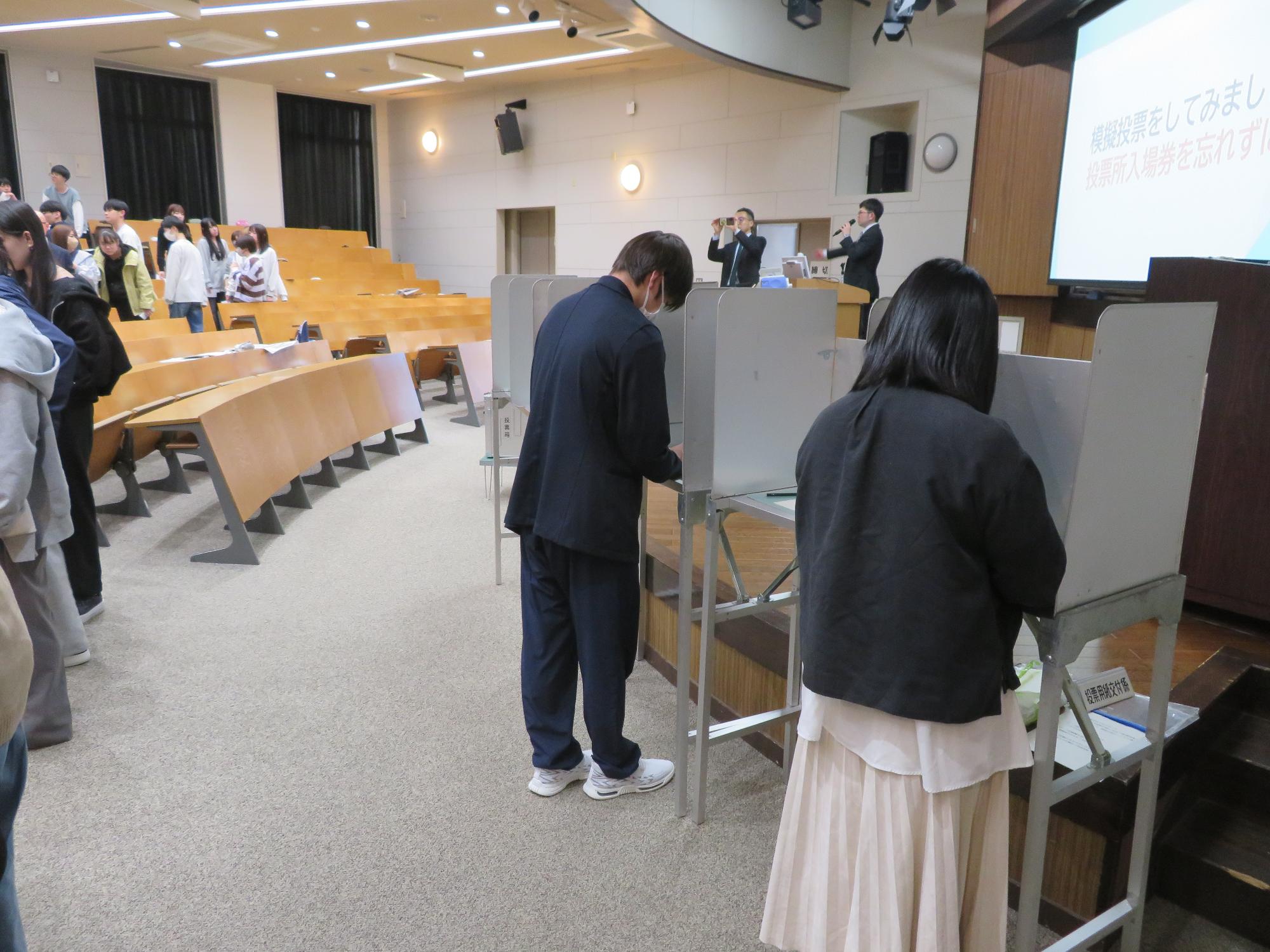 投票用紙を交付する高校生スタッフ