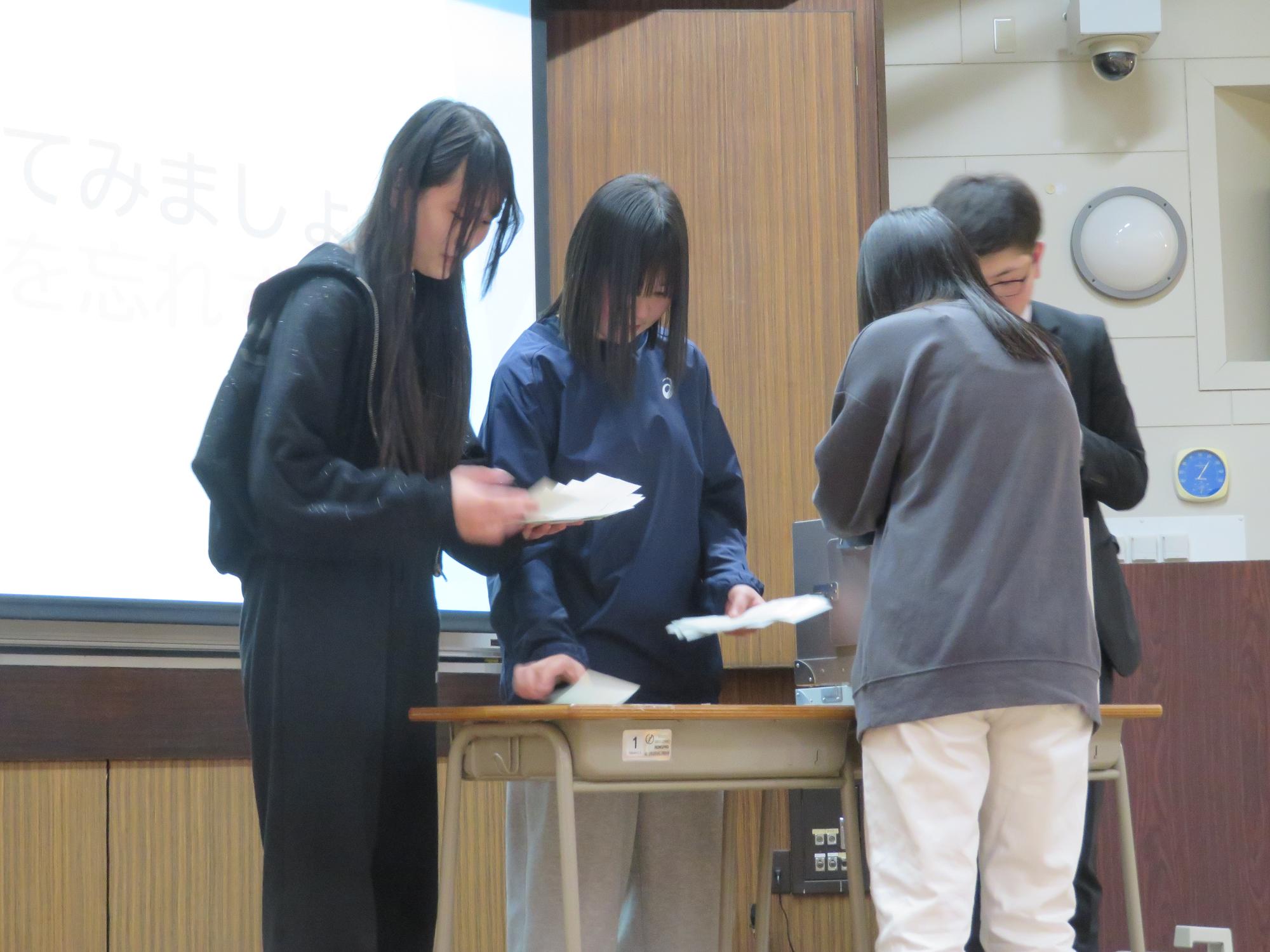 投票箱に投票用紙を投函する高校生