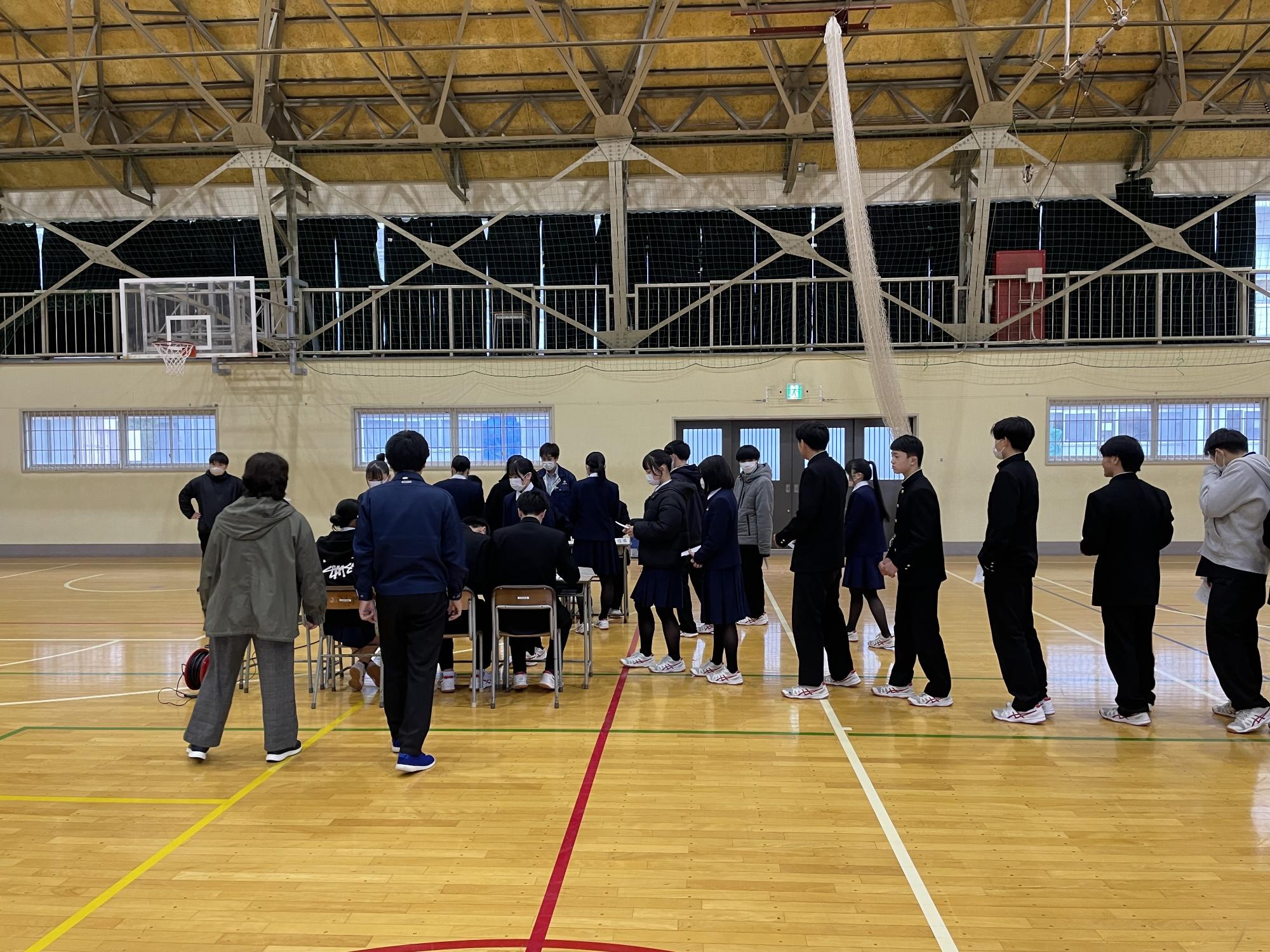 模擬投票所に並ぶ高校生の写真