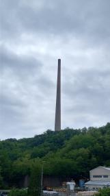 厚い雲が覆っている空をバックに、山の上にそびえ立つ大きなラサの煙突の写真