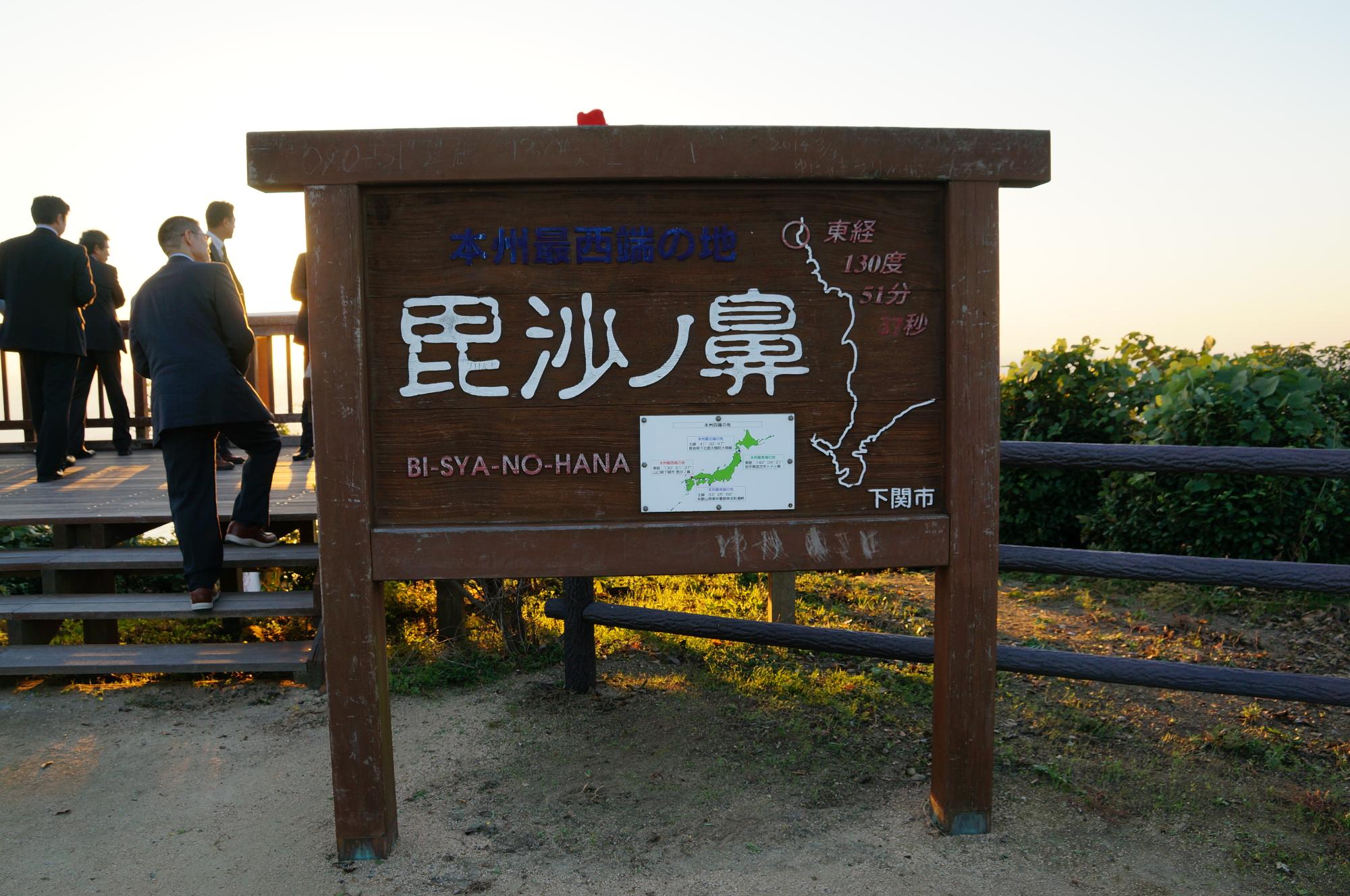毘沙ノ鼻と書かれた看板が設置された奥の見晴台に大勢の観光客が訪れている、本州最西端の下関市毘沙ノ鼻の写真