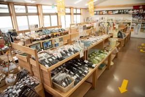 木製の棚にたくさんの種類の食品が陳列されている直産販売所の写真