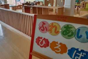 木材の塀で囲まれ、入り口に「ふれあいひろば」と書かれた案内がある広場の写真