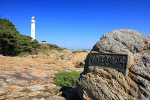手前の岩に「本州最東端の碑」と案内があり奥に白い灯台がみえるトドヶ崎の写真