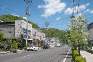 晴れた日に、街路樹や道路を走行している車、電柱などが映る宮古市市街地の写真