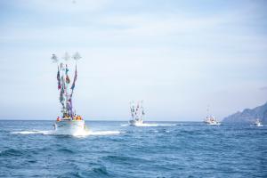 広大な海の上を3隻の船が並びながら走行している様子を写した写真
