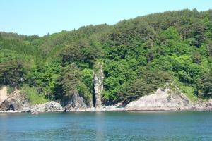 崖沿いにある海岸に突き出た高さ40メートほどのローソク岩を海側から撮影した写真