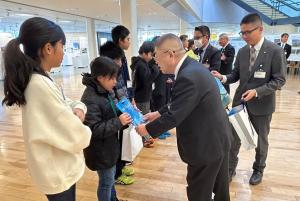沖縄県多良間村の児童一人一人に記念品を手渡している市長の写真