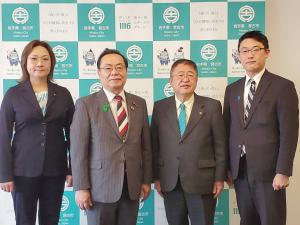 自由民主党東日本大震災復興加速化本部の本部長代理の谷公一衆議院議員、事務局長代理の藤原崇衆議院議員、本部員の高階恵美子衆議院議員と市長がバックパネルの前で並んで記念撮影をしている写真