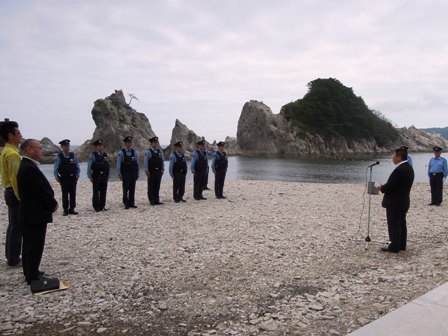 浄土ヶ浜の海水浴場で、関係者と警察官が並んでおり、マイクスタンドで話をする市長の写真