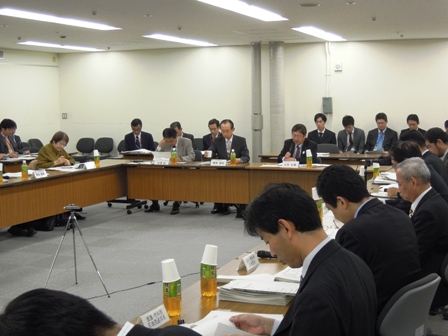 コの字型に設置された長机の席に、関係者が座っており、市長が報告している写真