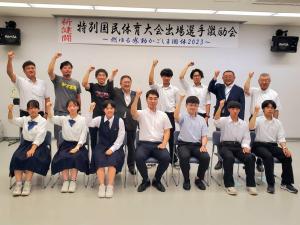 前列に椅子に座り制服を着た学生と関係者2名、後列に学生の関係者立ち8名が立って並んでいる記念写真