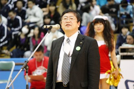 体育館の会場で市長がマイクに向かい挨拶をしている写真