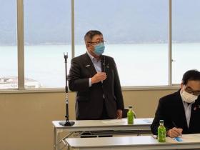 並べられた長テーブルの前に市長が立ち、マイクを片手に持ちながら意見を述べている写真