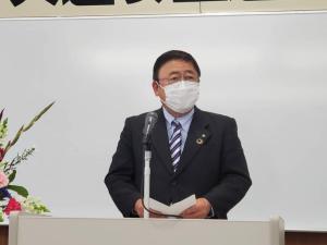 紺と白のストライプ柄のネクタイを締めた市長が、檀上で挨拶を行っている「秋の交通安全運動表彰式」の様子の写真