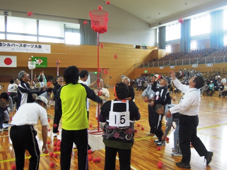 体育館の中で年配の方達が市長と一緒に玉入れをしている写真