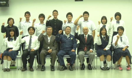 国民体育大会出場選手の皆さんと、市長、関係者が一緒に並び、1列目は椅子に座り、2列目は立って右腕の拳を握り右手を上げるポーズを取っている写真