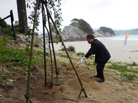 浄土ヶ浜地内で、スコップを手に持ち植樹をする市長の写真