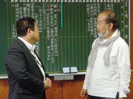 黒板前で向かい合って話をする市長と鎌田實先生の写真