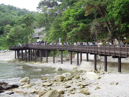 海岸に沿って作られた歩道を歩く人達の写真