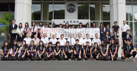 宮古市役所前で、市長と関係者、宮古高校女子ヨット部と宮古商業高校女子ヨット部の皆さんが、横3列に並び横断幕を持っている写真