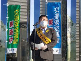 宮古駅前で交通安全運動実施中と書かれた、青色と緑色の幟が立っている中、市長が交通安全運動実施中と書かれた黄色の襷をかけ、交通安全運動について話をしている写真
