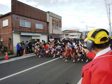 スタート地点でスターターピストルが鳴り大勢の人達が一斉にスタートした写真