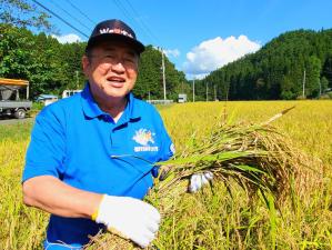 収穫した稲の束を持つ市長の写真