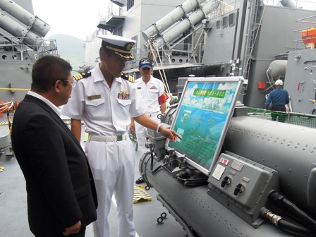 「すずなみ」の護衛艦内で、海上自衛隊員がパネルを指しながら市長に説明する様子の写真