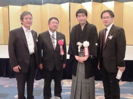 金屏風の前で市長と関係者が4人で並んでいる写真