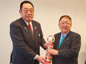 伊藤康志市長と市長が二人でこけしをもって記念撮影をしている写真